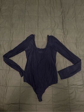Navy blue long sleeve bodysuit with a scoop neckline and a low back never worn